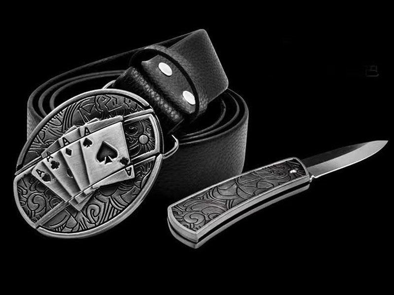 Black leather belt with engraved metal buckle featuring playing cards design, paired with an engraved knife handle.