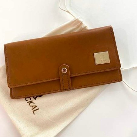 Brown leather purse with a rectangular gold metal logo plate